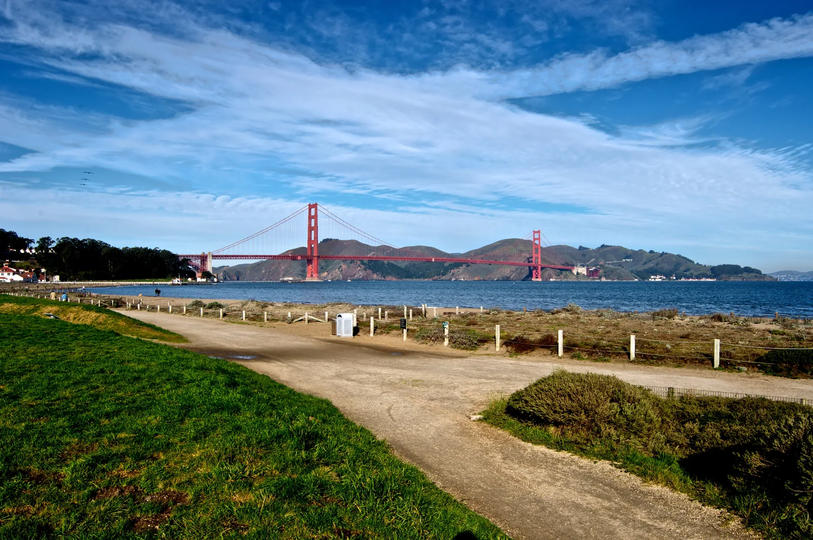 The Golden Gate Bridge seen from Crissy Field, San Francisco, with the bay and shoreline path in the foreground.